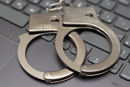 online fraud on the internet. handcuffs on the keyboard.の写真素材