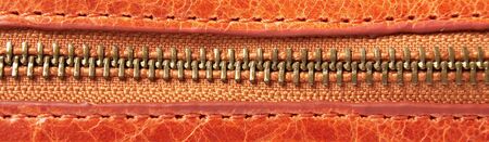 Detail of a zipper on orange leatherの写真素材