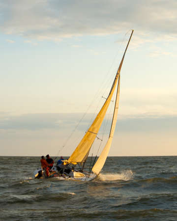 Yacht sailing against sunset. Holiday lifestyle landscape with skyline sailboatの写真素材