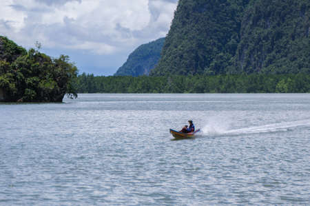 The Boat on the Bay surrounded by Islands with Mangroves. Islands at Phang Nga Bay near Krabi and...
