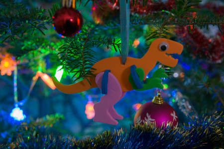 Dino Christmas-Tree Decorations on a Christmas-Tree Branch with Christmas Balls and Christmas-Tree Setの写真素材