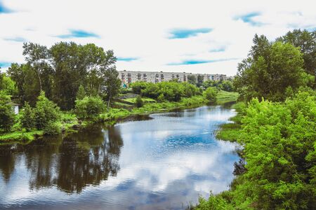 Summer river surrounded by treesの写真素材