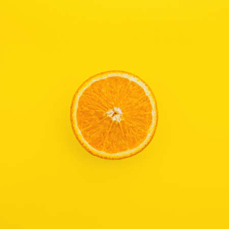 slice of orange fruit on a yellow backgroundの写真素材