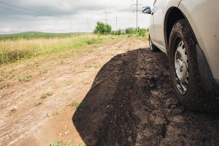 dirt under the wheel of car, near the forest