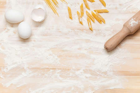 Rolling pin on a light wooden table with flourの写真素材