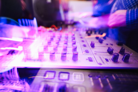 Club DJ playing mixing music on vinyl turntable at party