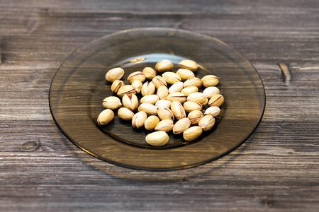 Pistachio nuts on wooden background, close upの写真素材