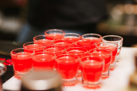 Several shot glasses on table in bar settingの写真素材
