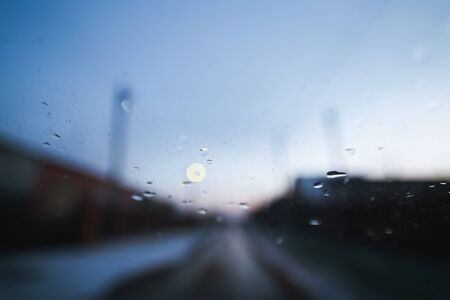 Raindrops on windshield of moving car on countryside roadの写真素材