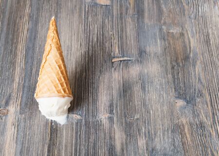 Flipped vanilla ice cream in a waffle cones on wooden background