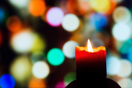 Burning candle on background of colorful circles.の写真素材