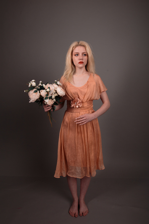 Living doll girl with flowers on gray backgroundの写真素材
