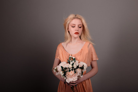 Living doll girl with flowers on gray backgroundの写真素材