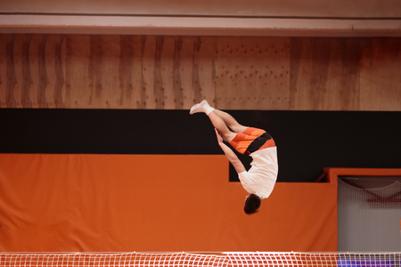Young athlete on the trampoline in the graceful flight.