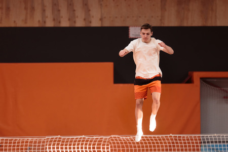 Young athlete on the trampoline in graceful flight.の写真素材