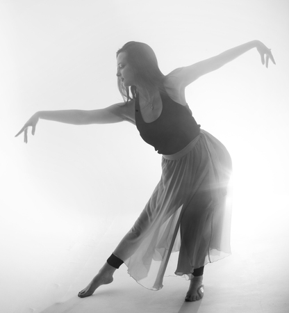 Beautiful girl elegantly dances in smoke and fog.の写真素材