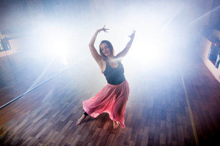 Beautiful girl elegantly dances in smoke and fog.の写真素材