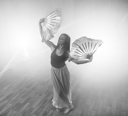 Beautiful girl elegantly dances in smoke and fog.の写真素材