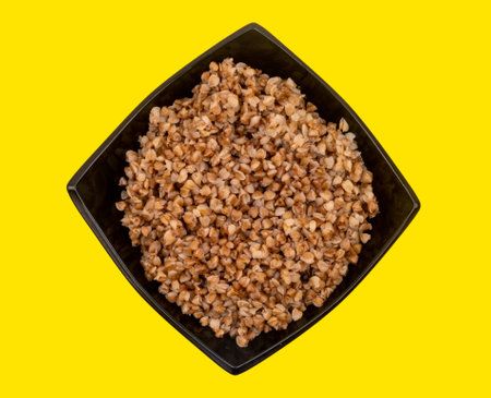 buckwheat on a plate in top view, isolated on yellow background. High quality photoの写真素材