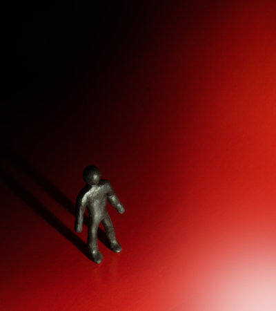 Psychology or religion concept - highlighted clay character standing and looking on spotlight with drop long shadow. Thematical conceptual photoの写真素材