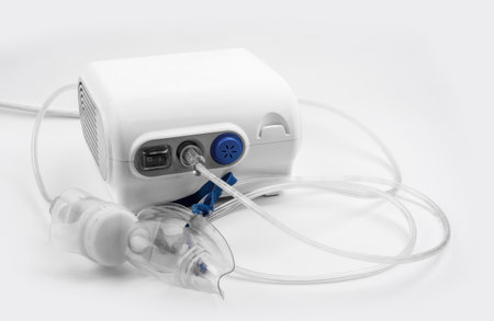 Ultrasonic inhaler or nebulizer. Respiratory medicine. Asthma breathing treatment with oxygen mask, medical equipment for inhalation on white background. High quality photoの写真素材