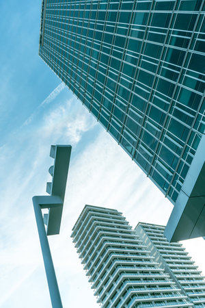 Modern skyscrapers in business district with blue cloudy sky and in perspective viewの写真素材