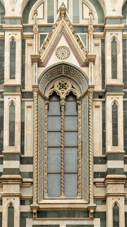Florence Cathedral facade window in Italy - Duomo di Firenze. Beautiful religious building with cloudy skyの写真素材