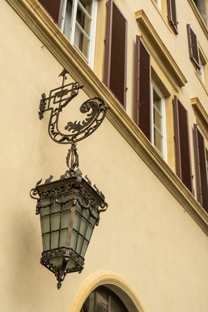Vintage lantern hanging on a house wall. Made from steel and glass, somewhere in Florence, Italyの写真素材