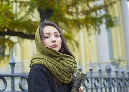 the girl walks down the street with a bookの写真素材