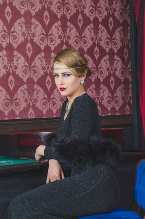 Girl in casino sitting at the table with a tape measureの写真素材