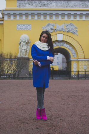 a girl stands in front of a yellow buildingの写真素材