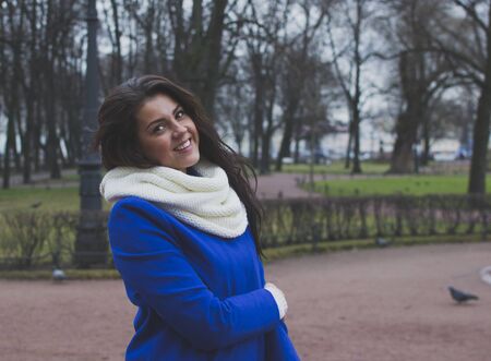 a girl in a bright coat walking around the cityの写真素材