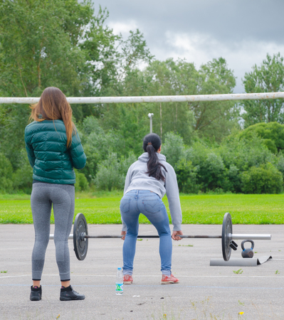 two girl doing deadlifts with a barbell on the Playgroundのeditorial素材