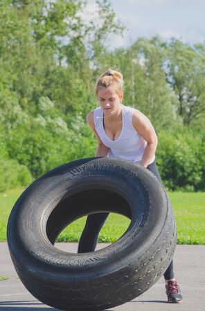 Russia Nikolskoe July 21016 competition at crossfit beautiful girl in a white pesters wheel front viewのeditorial素材
