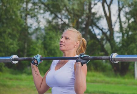 Russia Nikolskoe July 21016 competition for the crossfit girl in white pesters the barbell on your chestのeditorial素材