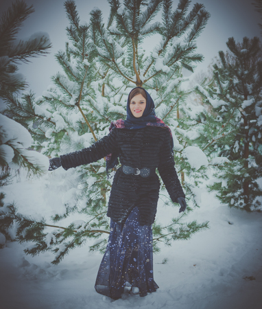 Russian beauty in the winter near snow-covered trees with snow in his hands.の写真素材