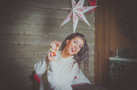 attractive girl in white sweater indulges in his hands Christmas toy.の写真素材