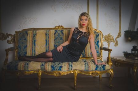 vintage sofa is a spicy girl in a black dress.の写真素材