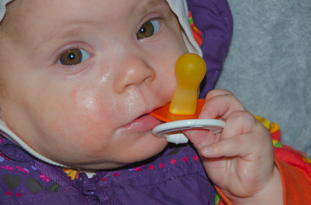 in a wheelchair calm the baby with a pacifier.