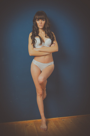 beautiful model in full-length standing with arms crossed the chest, on blue background .の写真素材