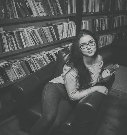 Russia, Saint-Petersburg Kazanskaya-7 October 25, 2016. black and white beautiful girl in the library sitting in a chair.のeditorial素材