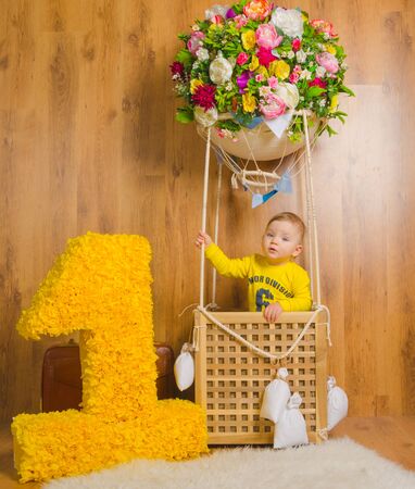 one year next to the basket of the balloon where the baby boy.の写真素材