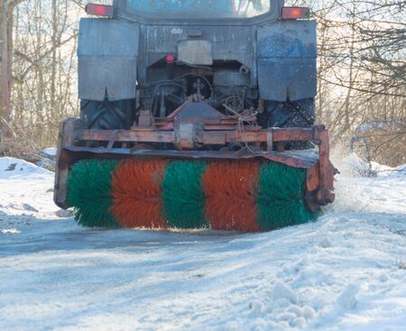 tractor cleans snow brush in the winter.