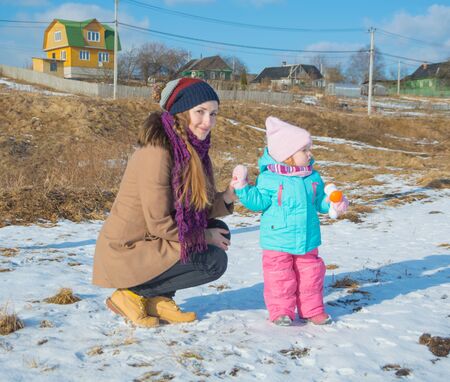 mom with child walk on foot along the road in the winter.のeditorial素材