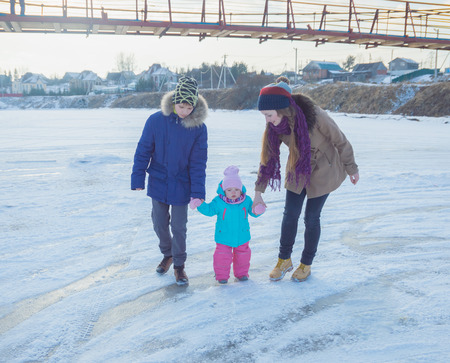 family, mom, brother and sister walking on the frozen river.のeditorial素材