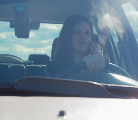 driving a car an attractive girl talking on the phone.
