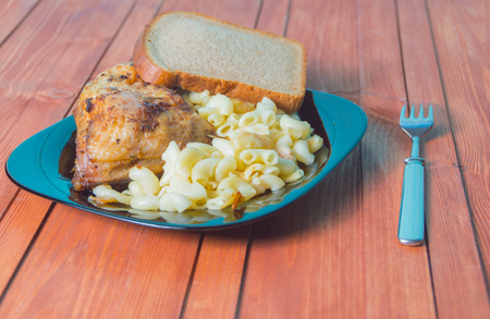 chicken with pasta on the wooden table.の写真素材