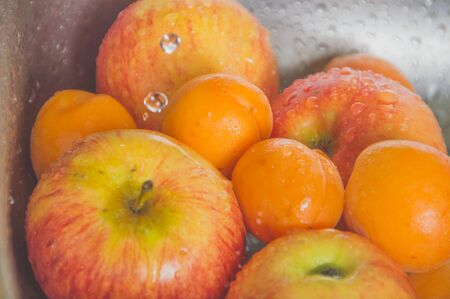 closeup of apples and peaches with drops of water.