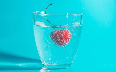 cherry in water with bubbles on a blue background.