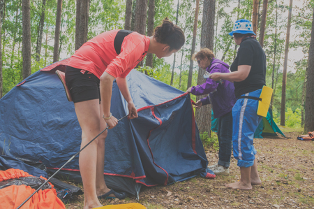 July 15, 2017 Russia, the Vuoksi river, Losevo - in the forest women put up a tent.のeditorial素材